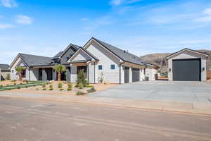 Modern farmhouse style home featuring concrete driveway, a standing seam roof, a mountain view, a metal roof, and a garage