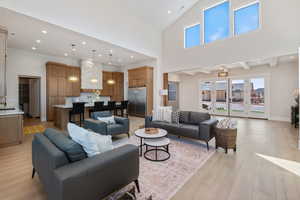 Living room featuring recessed lighting, high vaulted ceiling, and light wood-style floors
