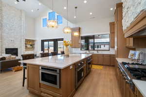 Kitchen with a breakfast bar area, tasteful backsplash, open floor plan, pendant lighting, and light wood-style floors