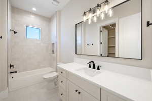 Bathroom featuring bathtub / shower combination, vanity, recessed lighting, and light tile patterned flooring