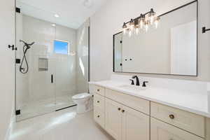 Full bath with vanity, a stall shower, light tile patterned flooring, and recessed lighting