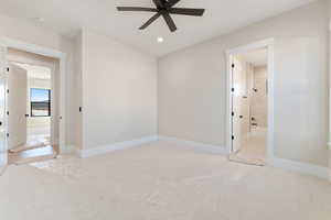 Unfurnished bedroom with light colored carpet, recessed lighting, ceiling fan, and ensuite bathroom