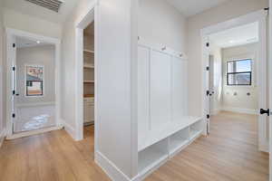 Mudroom with light wood-style floors and baseboards