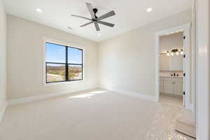 Unfurnished bedroom featuring light colored carpet, a ceiling fan, recessed lighting, and ensuite bath