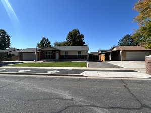 Ranch-style house with driveway, an attached garage, brick siding, and roof with shingles