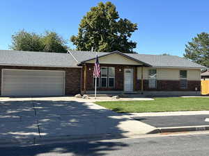 Ranch-style house featuring brick siding, driveway, a garage, a front yard, and a shingled roof