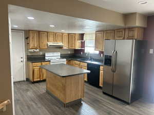 Kitchen with stainless steel fridge, dark countertops, a textured ceiling, electric stove, and dark wood-style floors