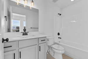 Bathroom featuring shower / tub combination, light tile patterned floors, and vanity