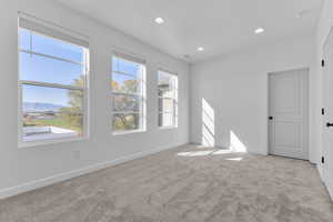 Empty room with light carpet, recessed lighting, and a mountain view