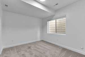 Unfurnished room featuring light colored carpet and baseboards