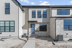 View of front facade featuring stone siding and stucco siding