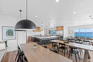 Dining space with light wood-style flooring, a water view, and recessed lighting