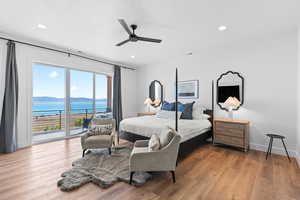 Bedroom featuring a water and mountain view, access to exterior, light wood-type flooring, recessed lighting, and a ceiling fan