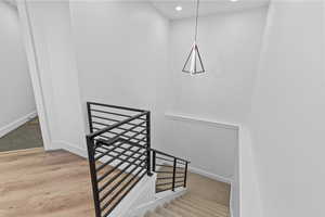 Stairs featuring recessed lighting and wood finished floors