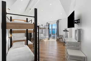 Bedroom featuring beam ceiling, light wood finished floors, access to exterior, high vaulted ceiling, and recessed lighting