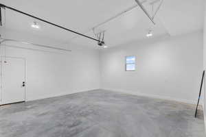 Garage featuring baseboards and recessed lighting