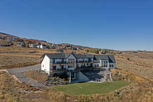 Rear view of property featuring a patio, a yard, and a mountain view
