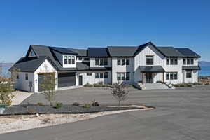 Modern farmhouse style home featuring a garage, board and batten siding, and asphalt driveway