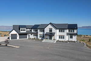 Modern farmhouse style home with a water and mountain view, a garage, driveway, and board and batten siding