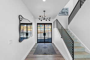 Foyer featuring a chandelier, wood finished floors, recessed lighting, and stairway
