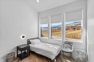 Bedroom with a mountain view, wood finished floors, and recessed lighting