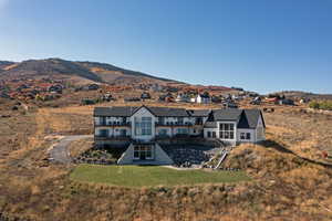 Back of property featuring a yard, a mountain view, and a patio area