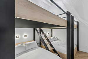 Bedroom with light wood finished floors and a textured ceiling