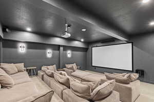 Carpeted cinema room with a textured ceiling and recessed lighting