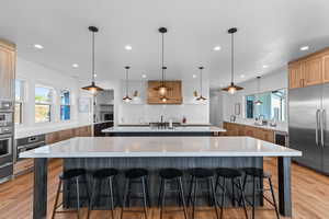 Kitchen with light stone countertops, tasteful backsplash, light wood-style flooring, and recessed lighting