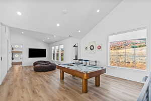 Game room with billiards table, light wood-style flooring, recessed lighting, and high vaulted ceiling