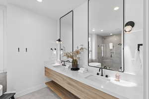 Full bathroom featuring a stall shower, double vanity, recessed lighting, and light tile patterned flooring