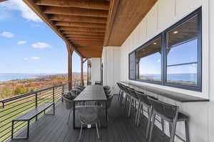 Wooden deck featuring outdoor dining area and a water view