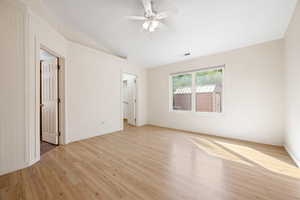 Spare room with light wood-style floors, a ceiling fan, and lofted ceiling