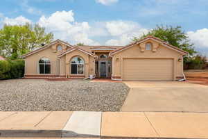 Mediterranean / spanish home with a tile roof, driveway, stucco siding, and a garage
