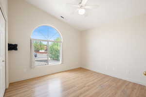Spare room with vaulted ceiling, light wood-type flooring, and ceiling fan