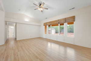 Spare room with light wood-type flooring, vaulted ceiling, and ceiling fan