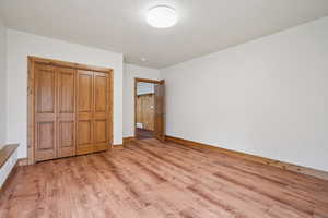 Unfurnished bedroom featuring light wood finished floors and a closet