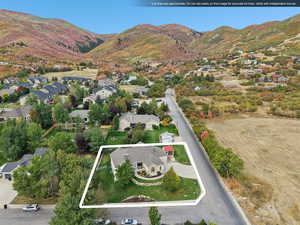 Aerial overview of property's location with property boundaries highlighted, nearby suburban area, and mountains