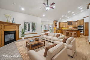 Living room featuring recessed lighting, a glass covered fireplace, high vaulted ceiling, and ceiling fan