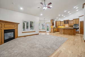 Kitchen featuring brown cabinets, decorative backsplash, recessed lighting, a kitchen island, and glass insert cabinets