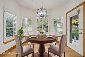 Dining room with wood finished floors and a chandelier