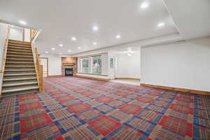 Below grade area featuring a fireplace, recessed lighting, stairway, and carpet floors