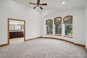 Unfurnished room with light carpet, recessed lighting, ceiling fan, and high vaulted ceiling
