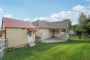 Rear view of house with entry steps, a patio, roof with shingles, and stucco siding