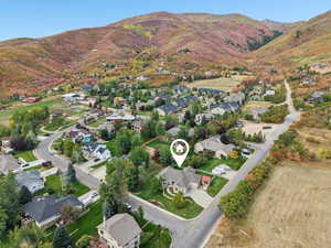 Aerial overview of property's location with nearby suburban area and a mountainous background