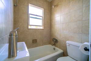 Full bathroom with tub / shower combination and tile walls