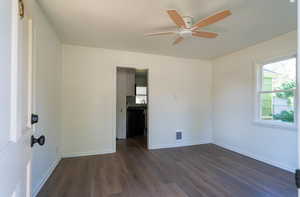 Spare room with dark wood-style flooring and ceiling fan