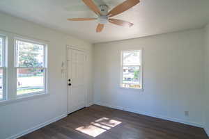 Foyer featuring dark wood-style flooring, a ceiling fan, and a textured ceiling