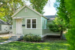 View of front of house with a shingled roof and a front yard