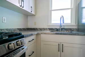 Kitchen with gas stove and white cabinetry